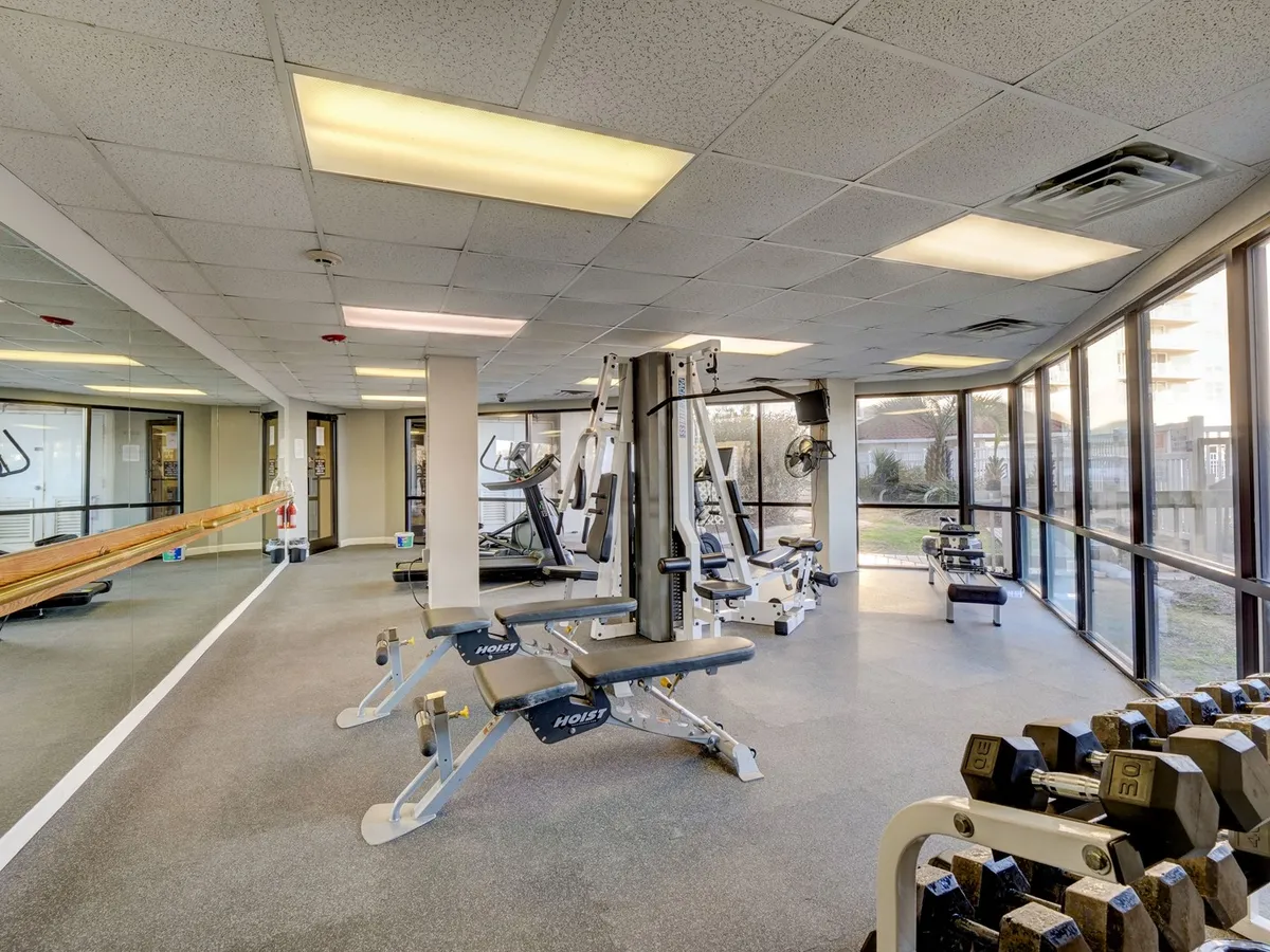 Inside the fitness center, this image highlights modern weightlifting equipment and exercise machines with large windows allowing natural light to flood the space. The setting is bright and motivating, inspiring guests to focus on wellness and self-care during their stay.