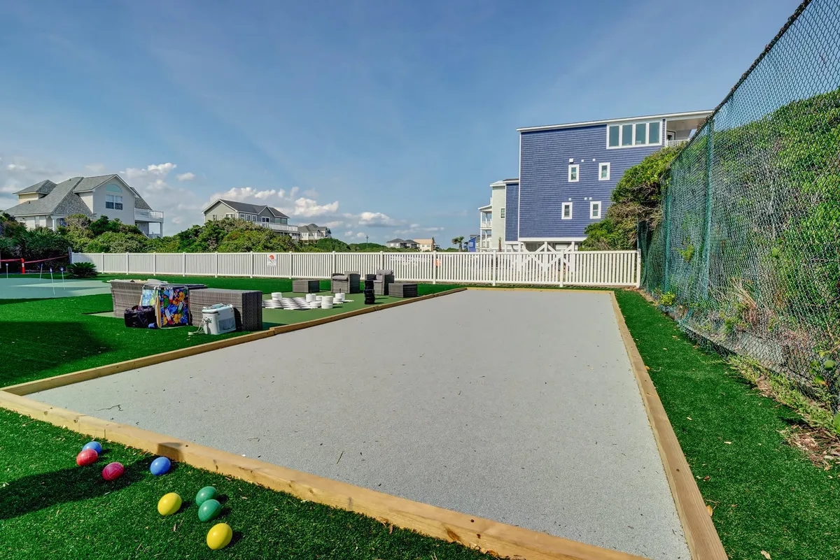 This exterior scene showcases a bocce ball court complete with colorful bocce balls and residential buildings in the background. The setting is lively and relaxed, suggesting opportunities for socializing and active recreation just steps from your door.